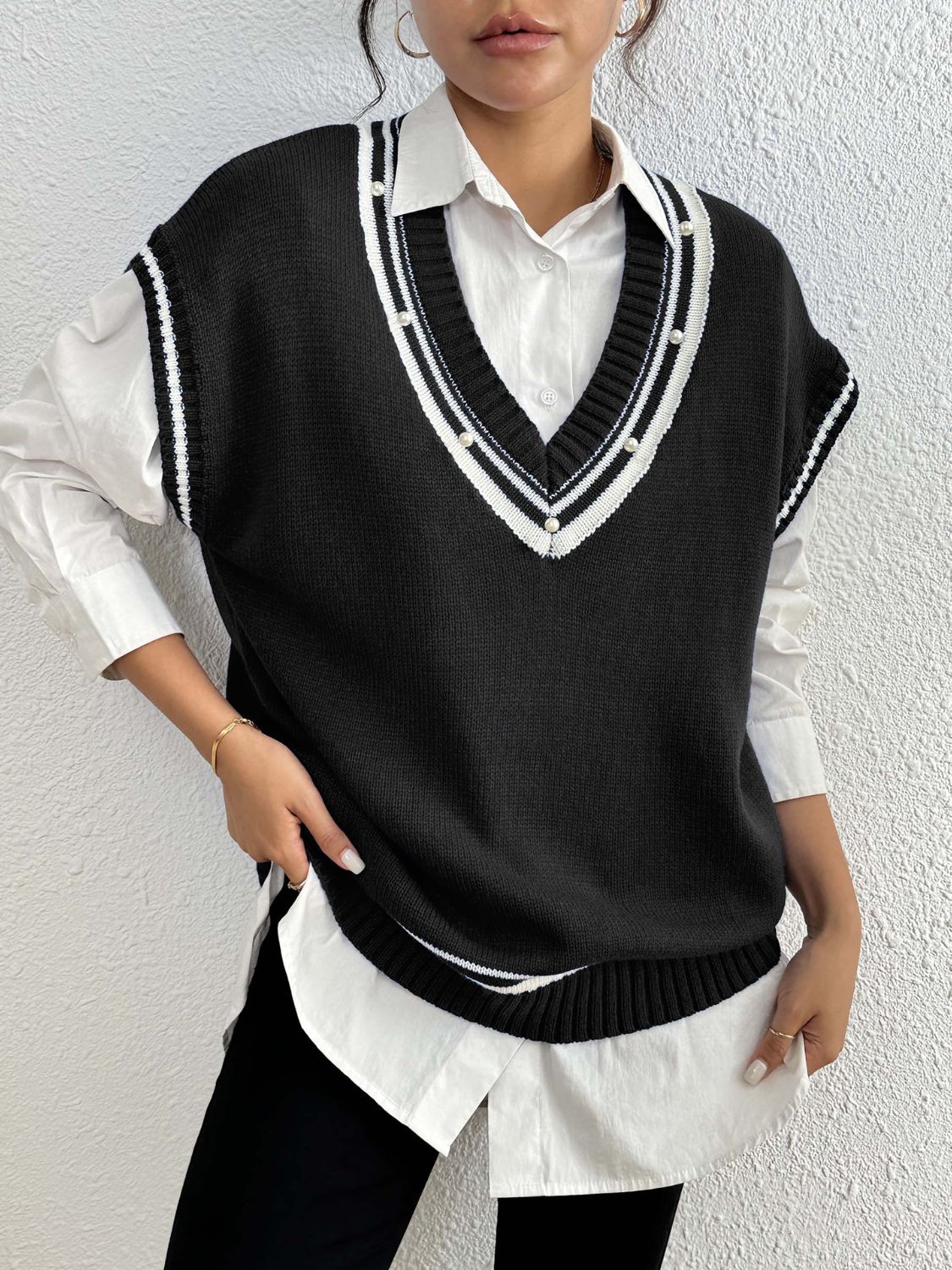 Black acrylic knit vest with varsity stripes and pearl trim neckline.