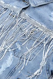 Medium wash denim trucker jacket with sequin fringe and distressed details.