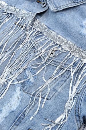 Medium wash denim trucker jacket with sequin fringe and distressed details.