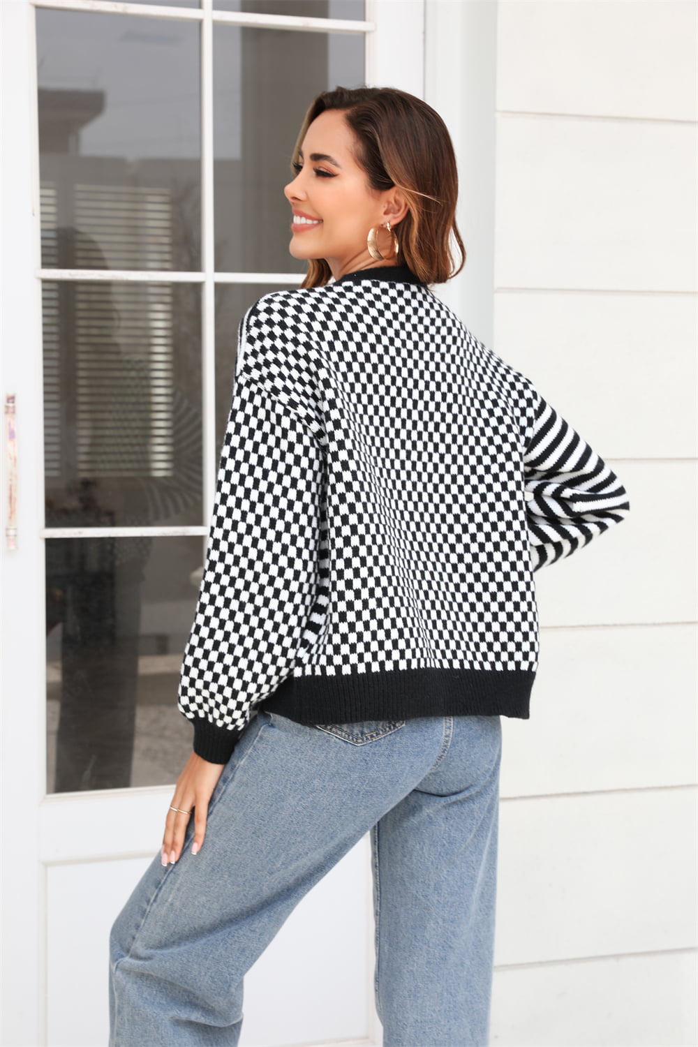Checkerboard sleeve contrast cardigan in black with buttoned front and ribbed trim.