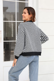 Checkerboard sleeve contrast cardigan in black with buttoned front and ribbed trim.