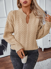 Camel cable knit sweater with keyhole neckline and ribbed cuffs.