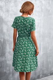 Crimson Floral Wrap Midi Dress in Light Green with short sleeves and a tie waist.