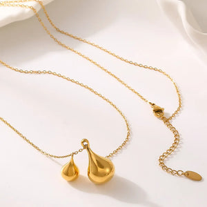 Gold necklace with two polished teardrop pendants, one large and one small.