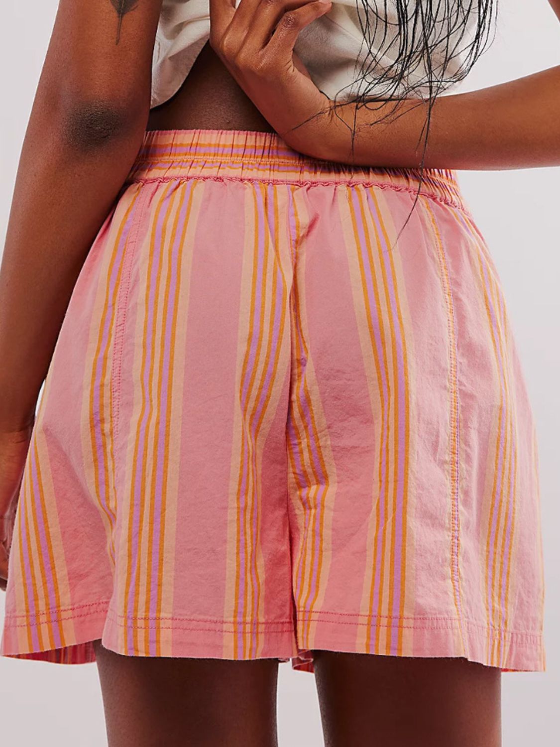 Elastic waistband stripe shorts in watermelon pink with purple and orange vertical stripes.