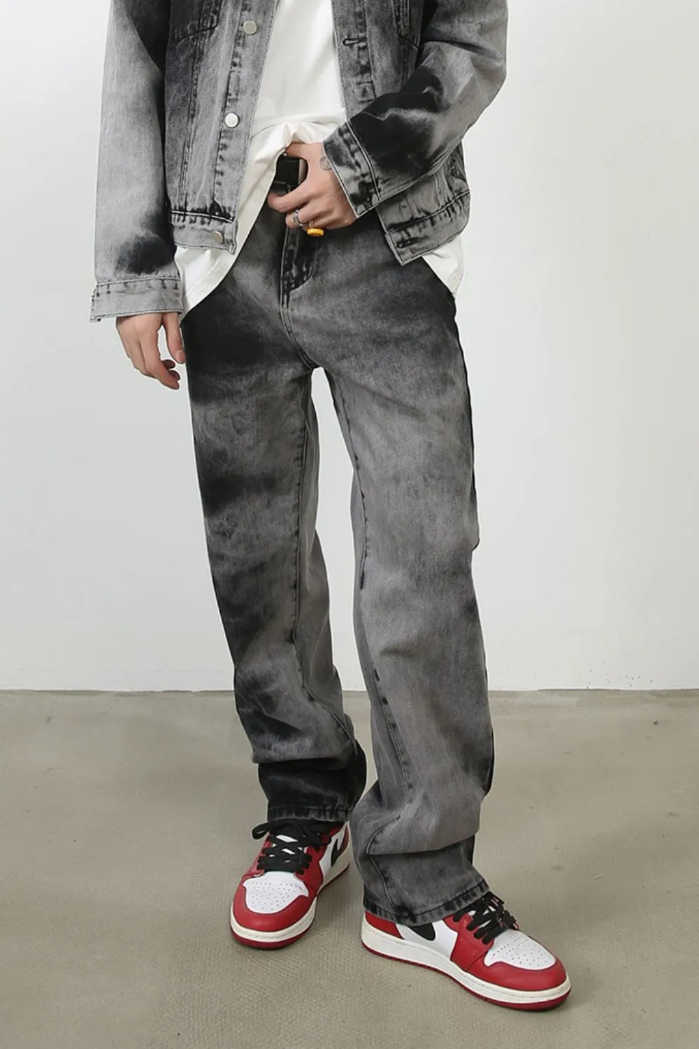 Charcoal wash straight leg denim jeans with a faded, marbled pattern.