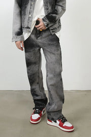 Charcoal wash straight leg denim jeans with a faded, marbled pattern.