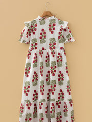 White cotton mini dress with red floral print, ruffled neckline and sleeves.