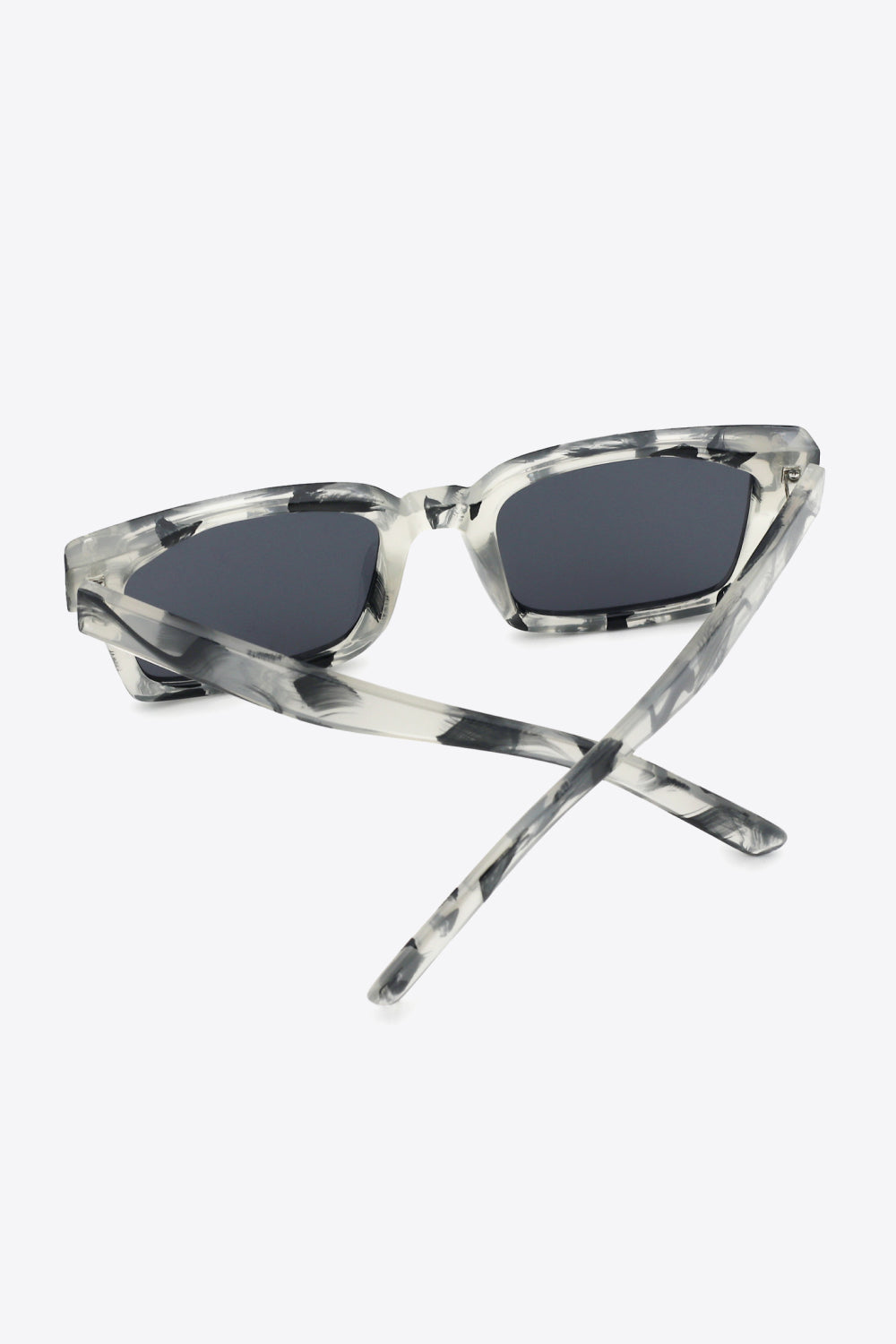 Marble effect rectangular sunglasses with dark lenses and clear frames.