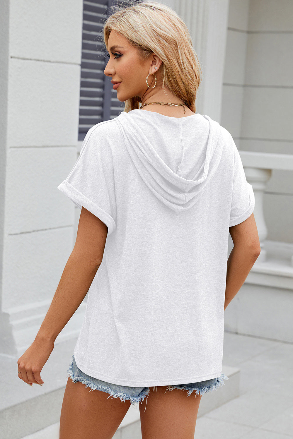 White hooded t-shirt with rolled short sleeves and a relaxed fit.