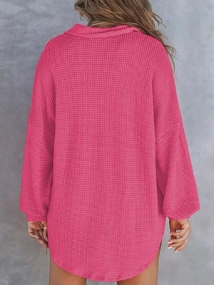 Waffle-knit Henley tee in dark pink with a collared neckline and long sleeves.