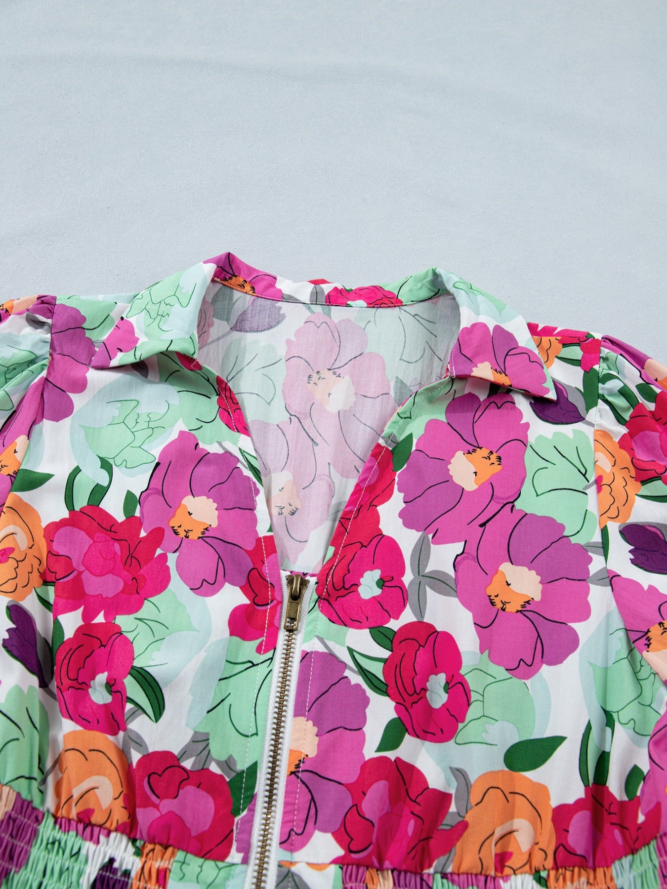 Floral V-neck zip midi dress with colorful floral print and smocked waist detail.