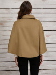 Camel cape jacket with gold buttons and asymmetric front detail.