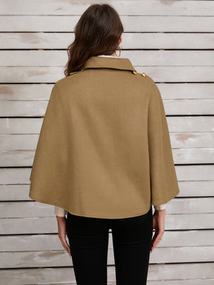 Camel cape jacket with gold buttons and asymmetric front detail.