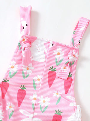 Pink baby overalls with bunny and carrot print, featuring adjustable tie straps.