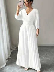 White pleated wide-leg jumpsuit with cinched waist and V-neckline.