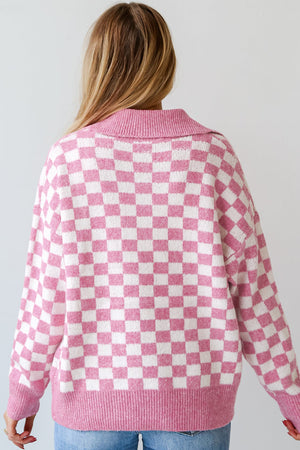 Pink checkerboard knit polo sweater with a collared neckline.