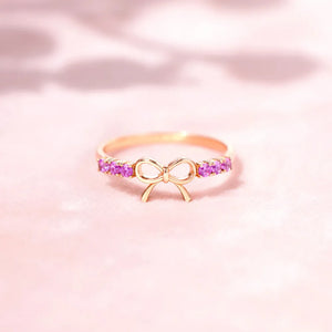Rose gold ring with bow detail and pink gemstone accents
