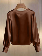 Brown satin blouse with round neck and long puff sleeves.