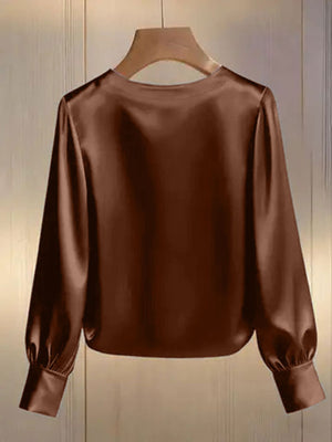 Brown satin blouse with round neck and long puff sleeves.