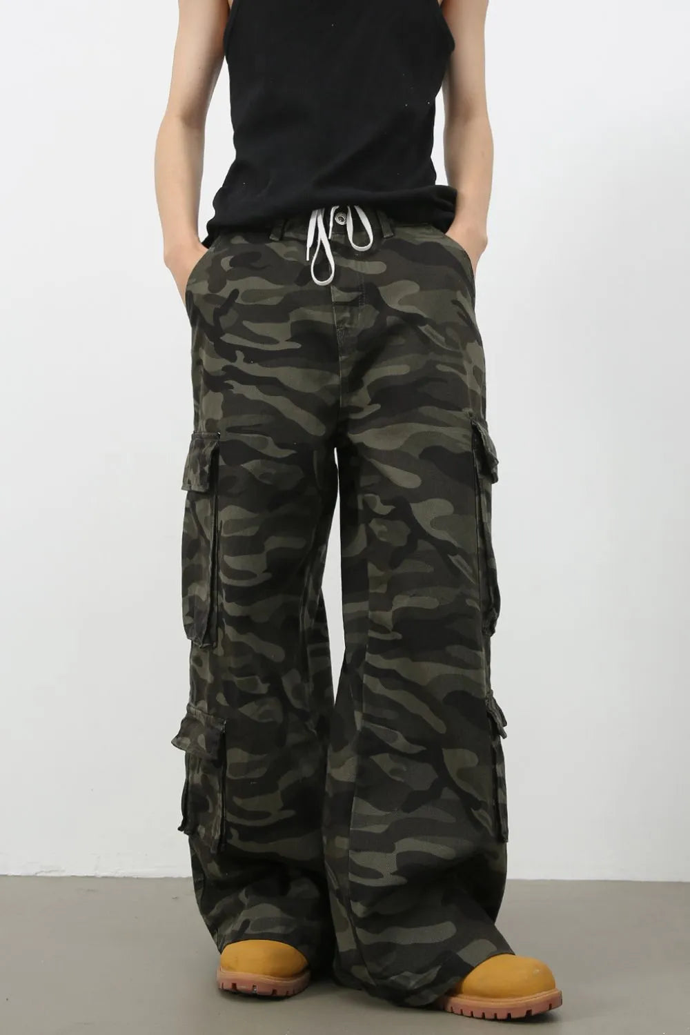 Wide-leg camo cargo pants in black with drawstring waist and multiple pockets.