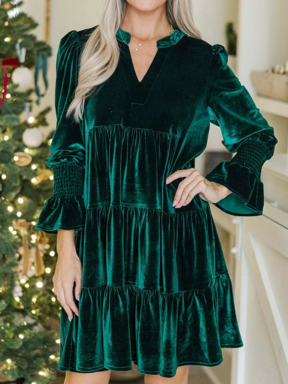 Dark green velvet tiered mini dress with notched neckline and smocked cuffs.