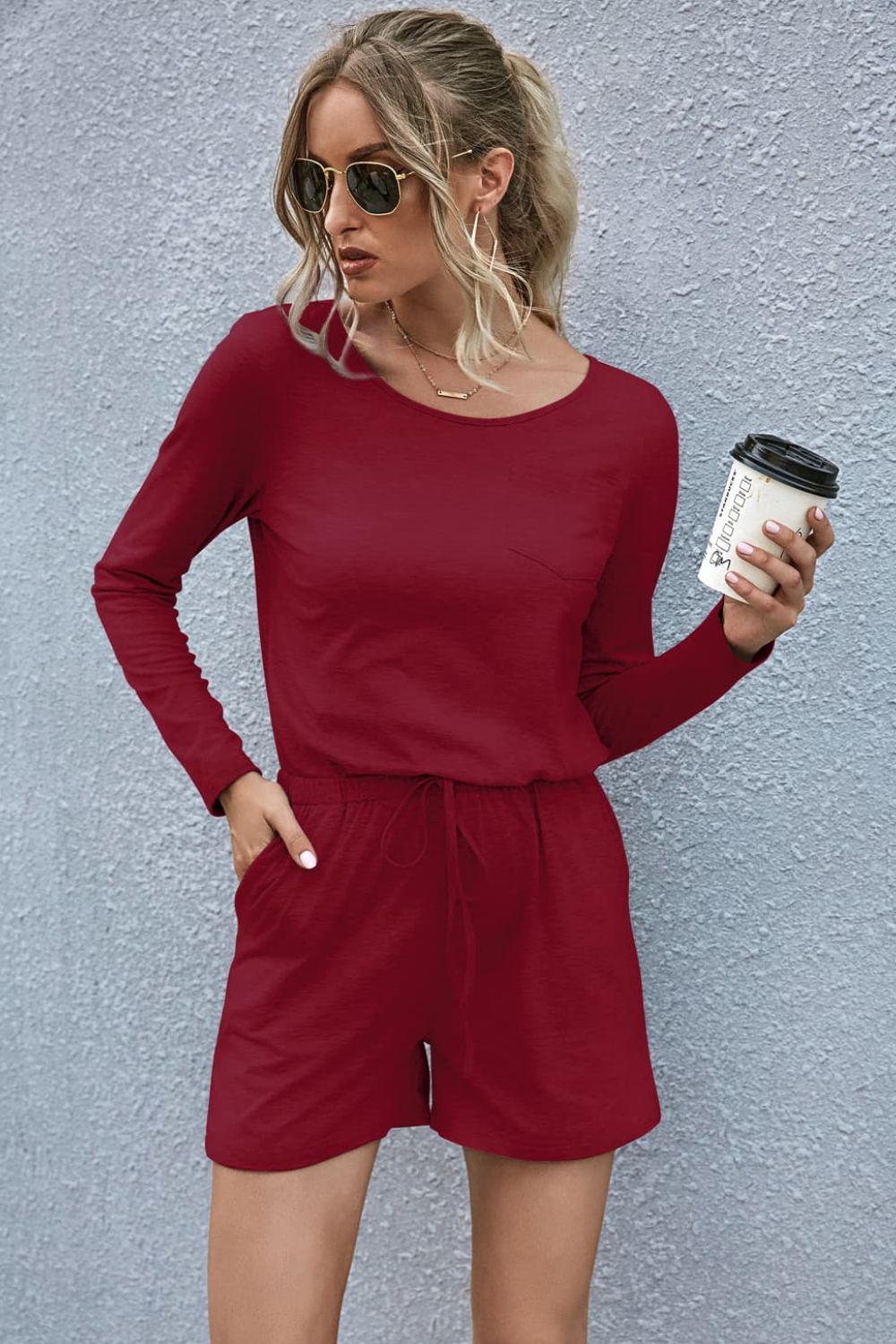 Wine jersey romper with long sleeves, drawstring waist, and chest pocket.