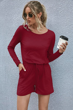 Wine jersey romper with long sleeves, drawstring waist, and chest pocket.