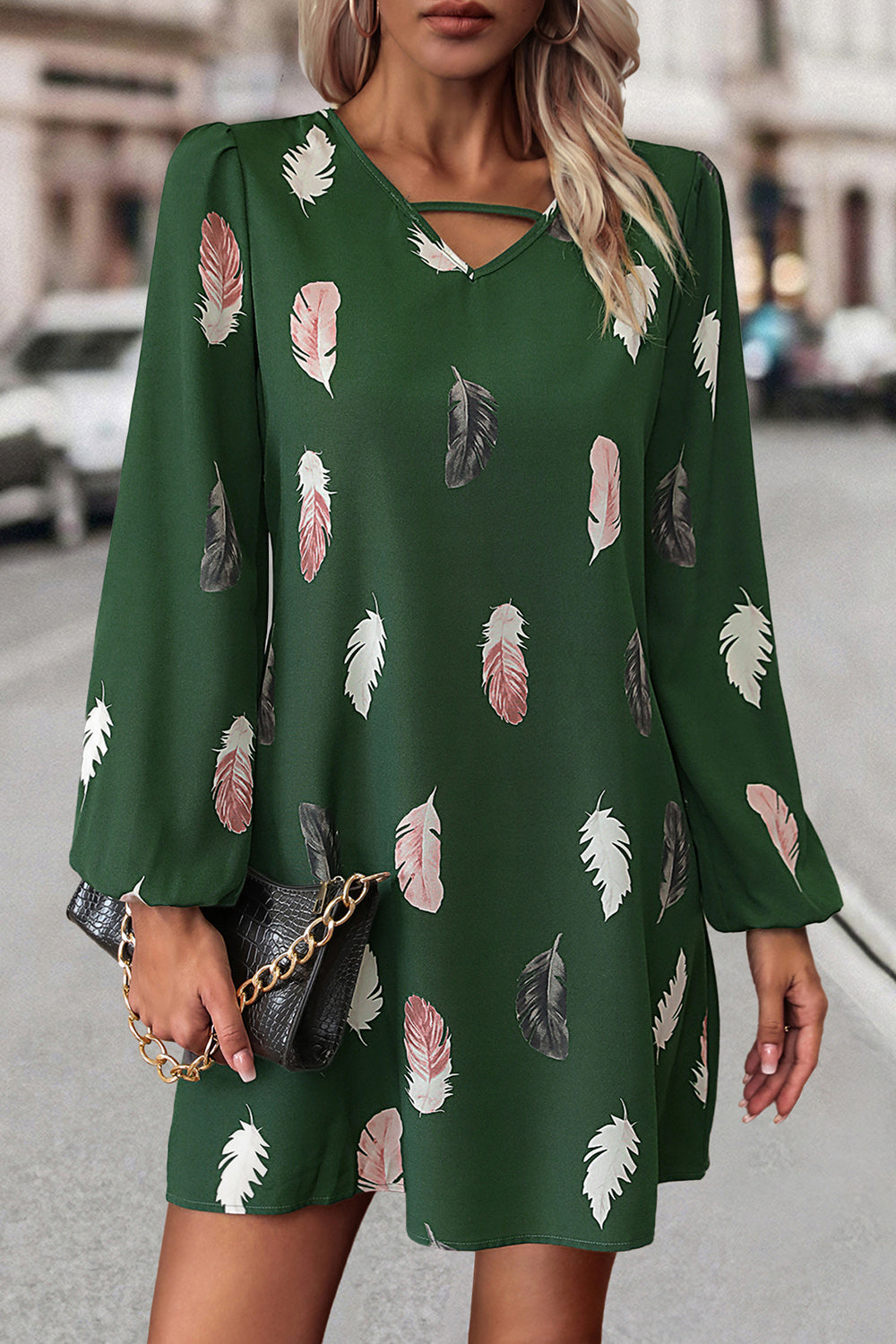 Green feather print mini dress with cutout neckline and long sleeves.