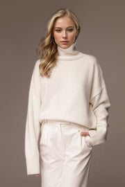 Oversized white cashmere turtleneck sweater with ribbed cuffs and hem.