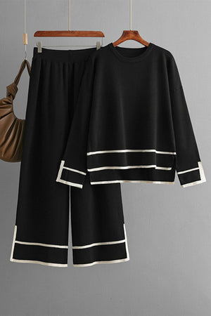 Black acrylic loungewear set with round neck top and wide leg pants, featuring contrast trim detail.