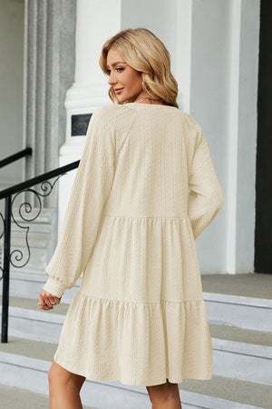 Cream textured babydoll mini dress with voluminous sleeves and tiered skirt