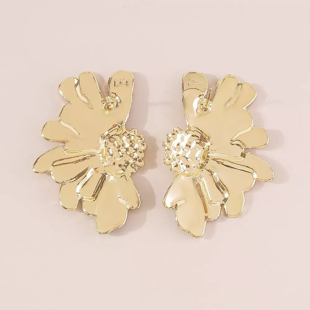 Textured gold flower stud earrings with detailed centers and petal accents.