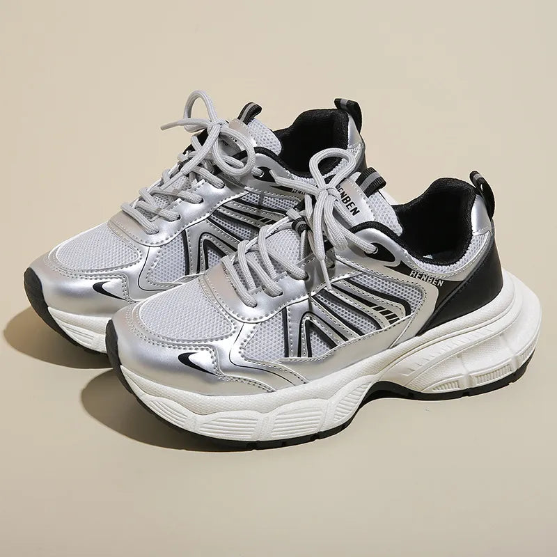 Chunky mesh runner sneakers in silver with black accents and a thick white sole.