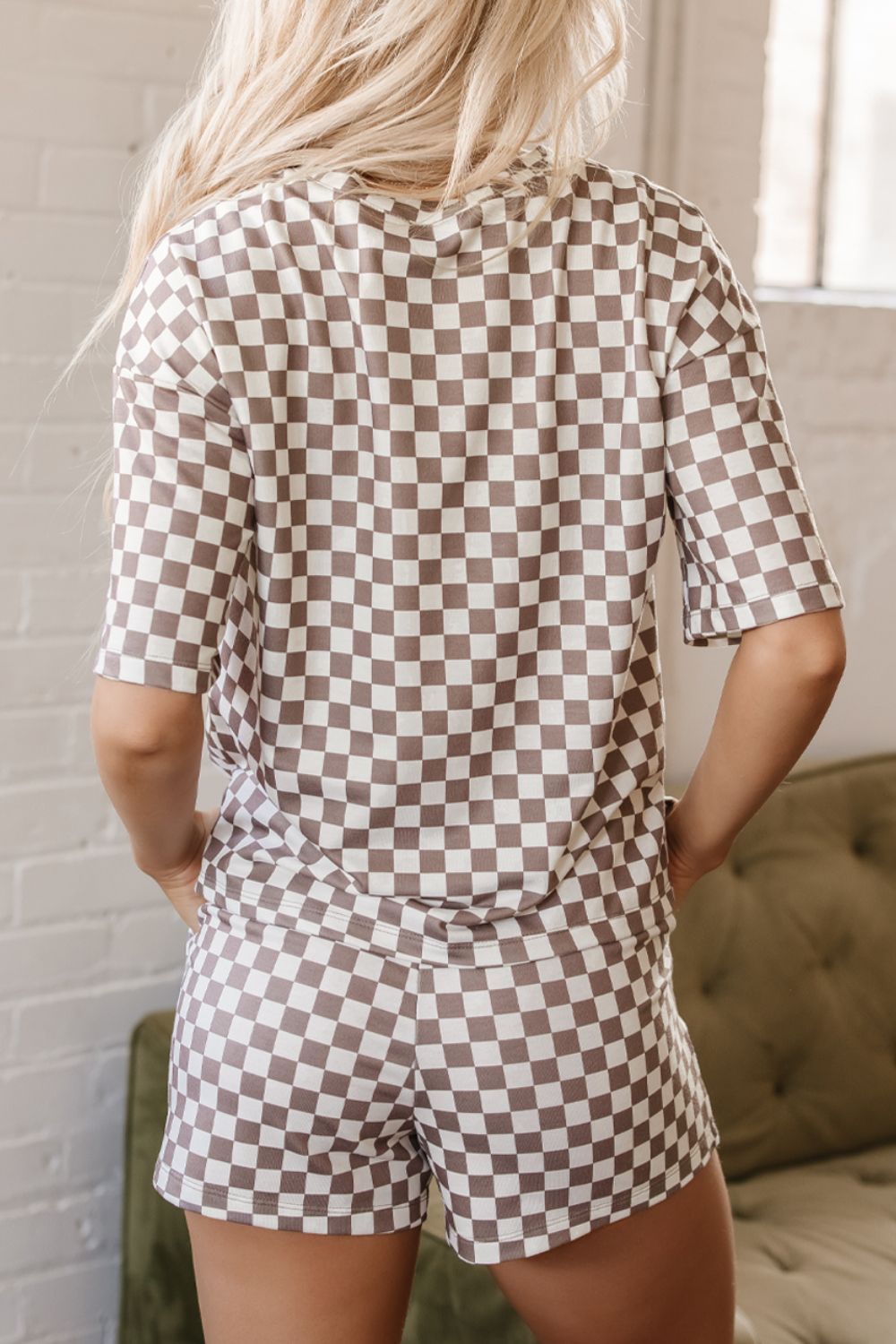 Checkered loungewear set with short sleeves and shorts in a brown and white pattern.