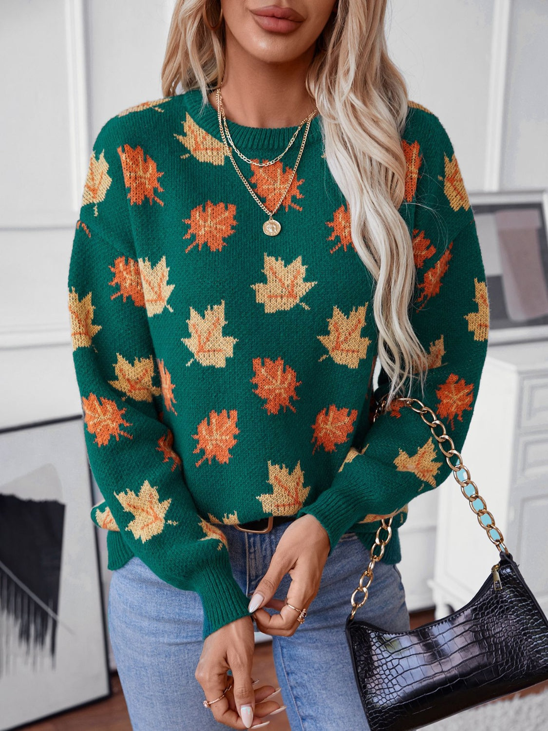 Green knit sweater with allover orange and yellow leaf pattern, crew neck, long sleeves.