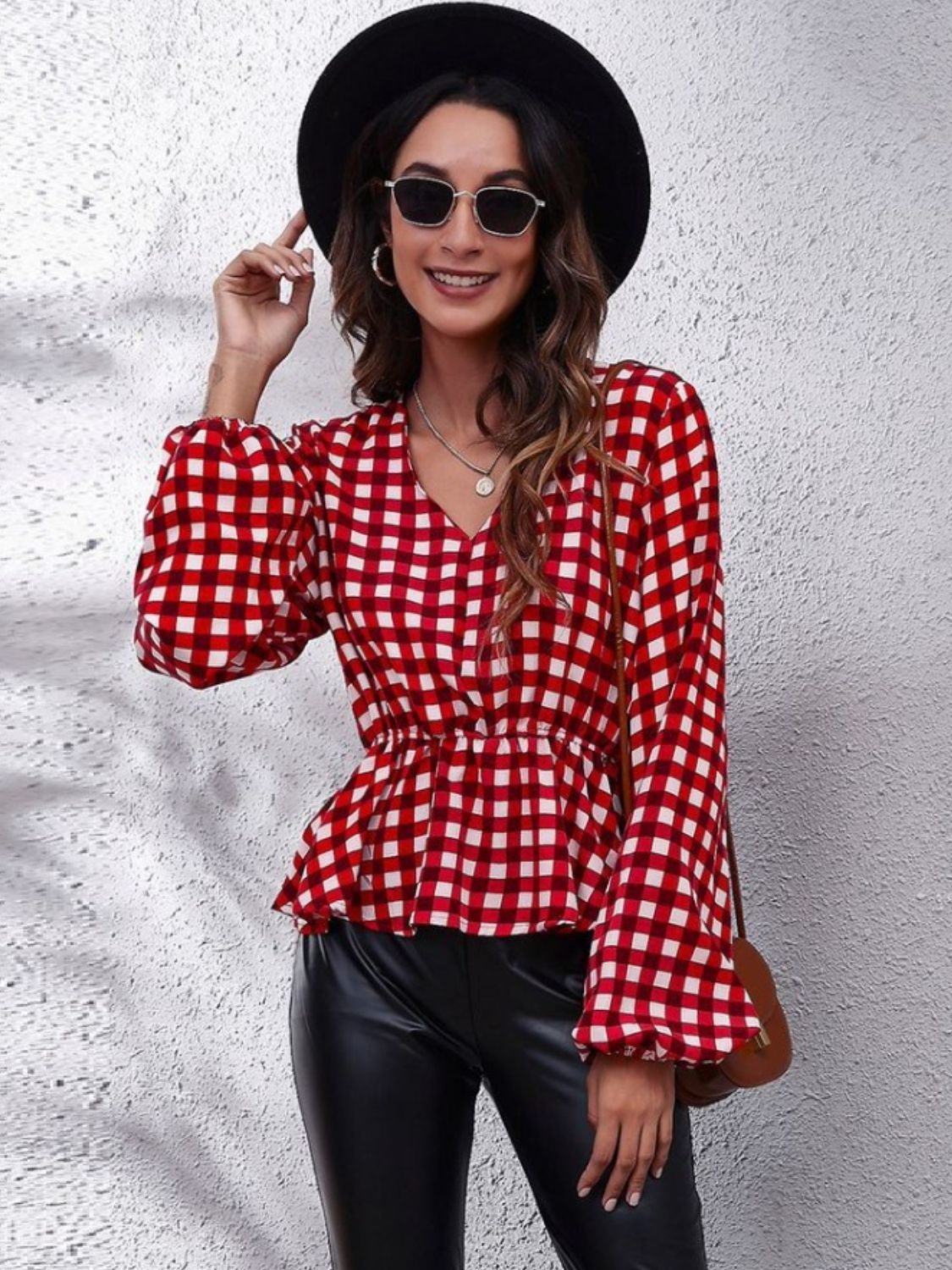 Red and white gingham peplum blouse with gathered waist and bell sleeves.