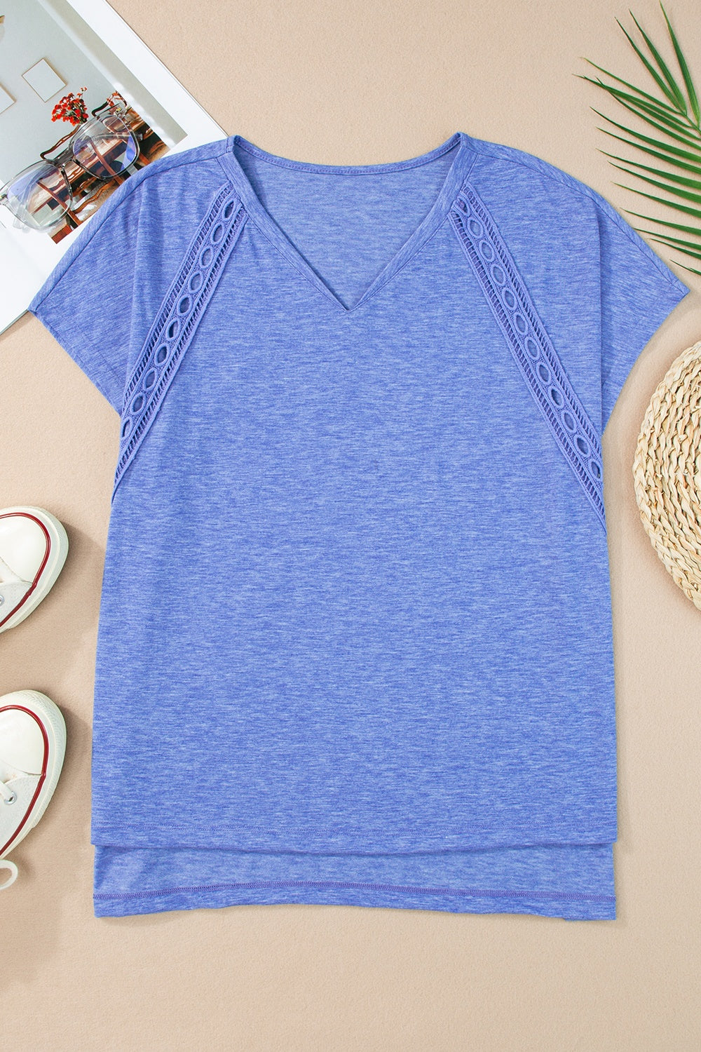 Dusty blue dolman sleeve blouse with perforated trim detail and V-neck.