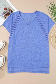 Dusty blue dolman sleeve blouse with perforated trim detail and V-neck.