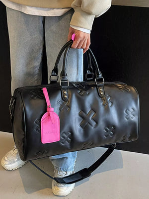 Black embossed cross detail luxury duffel bag with pink tag and strap.