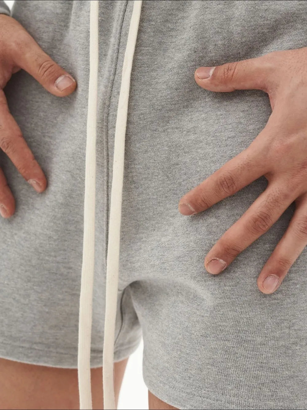 Relaxed fit gray cotton jersey jogger shorts with white drawstring detail.