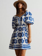 Blue floral puff sleeve mini dress with buttoned bodice and square neckline.