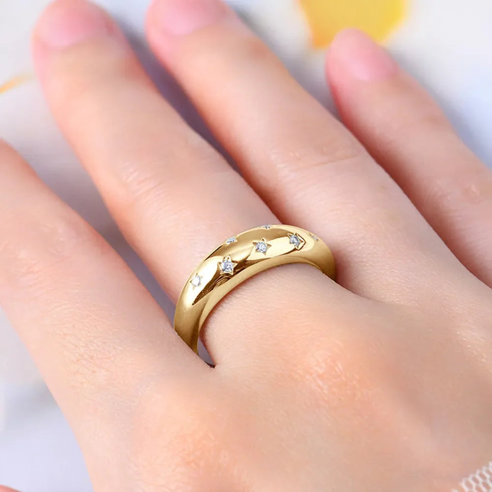 Gold dome ring with scattered starburst details and small stones.