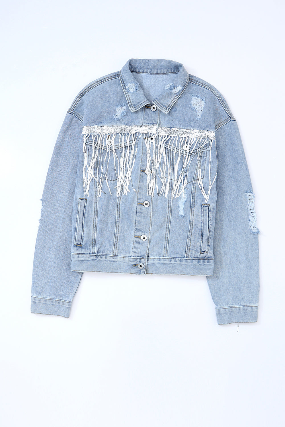 Medium wash denim trucker jacket with distressed details and white fringe accents.