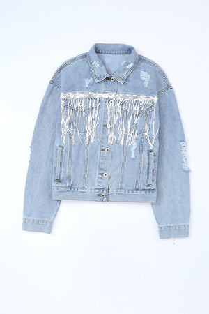 Medium wash denim trucker jacket with distressed details and white fringe accents.