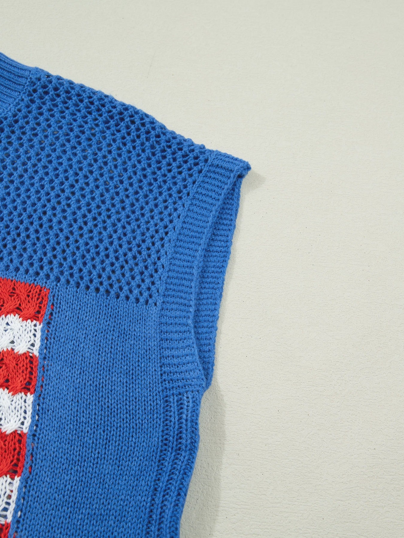 Blue acrylic knit top with American flag graphic detail and open knit sleeves.