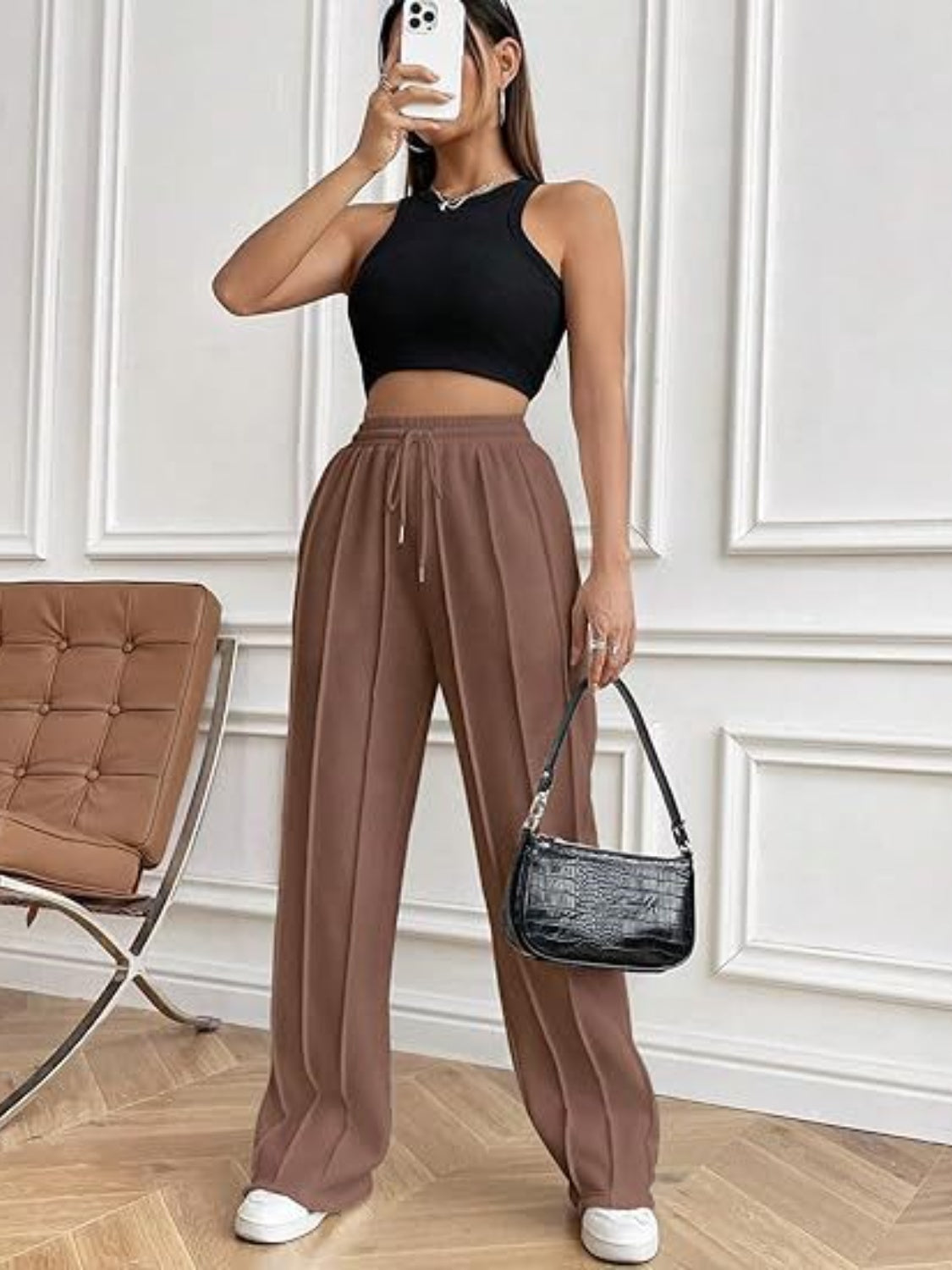 Brown pleated wide-leg lounge trousers with drawstring waist and front seams.