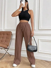 Brown pleated wide-leg lounge trousers with drawstring waist and front seams.