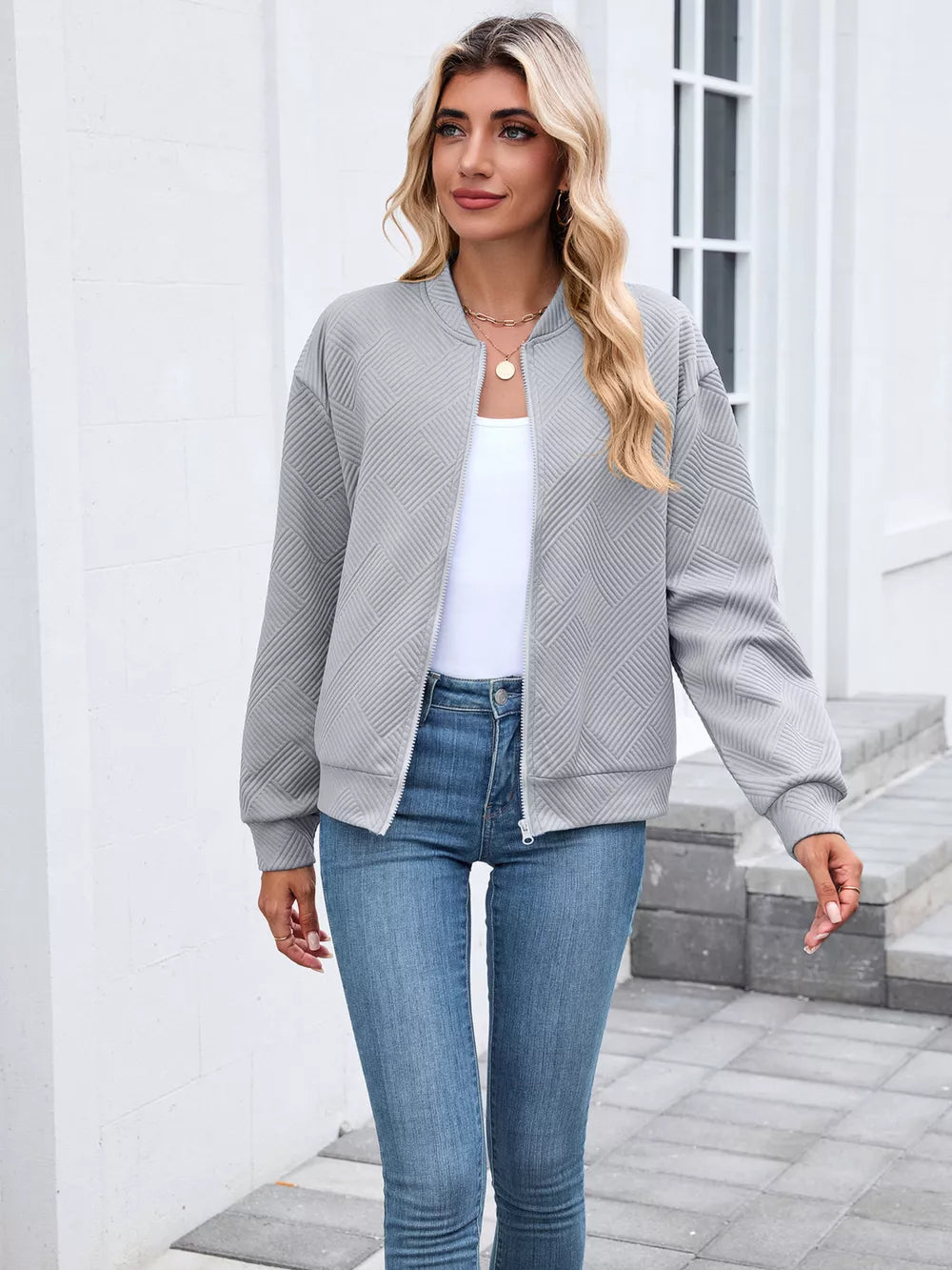 Black bomber jacket featuring zipper and geometric