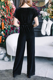 Black velvet wrap bodice jumpsuit with elastic waist and wide legs.